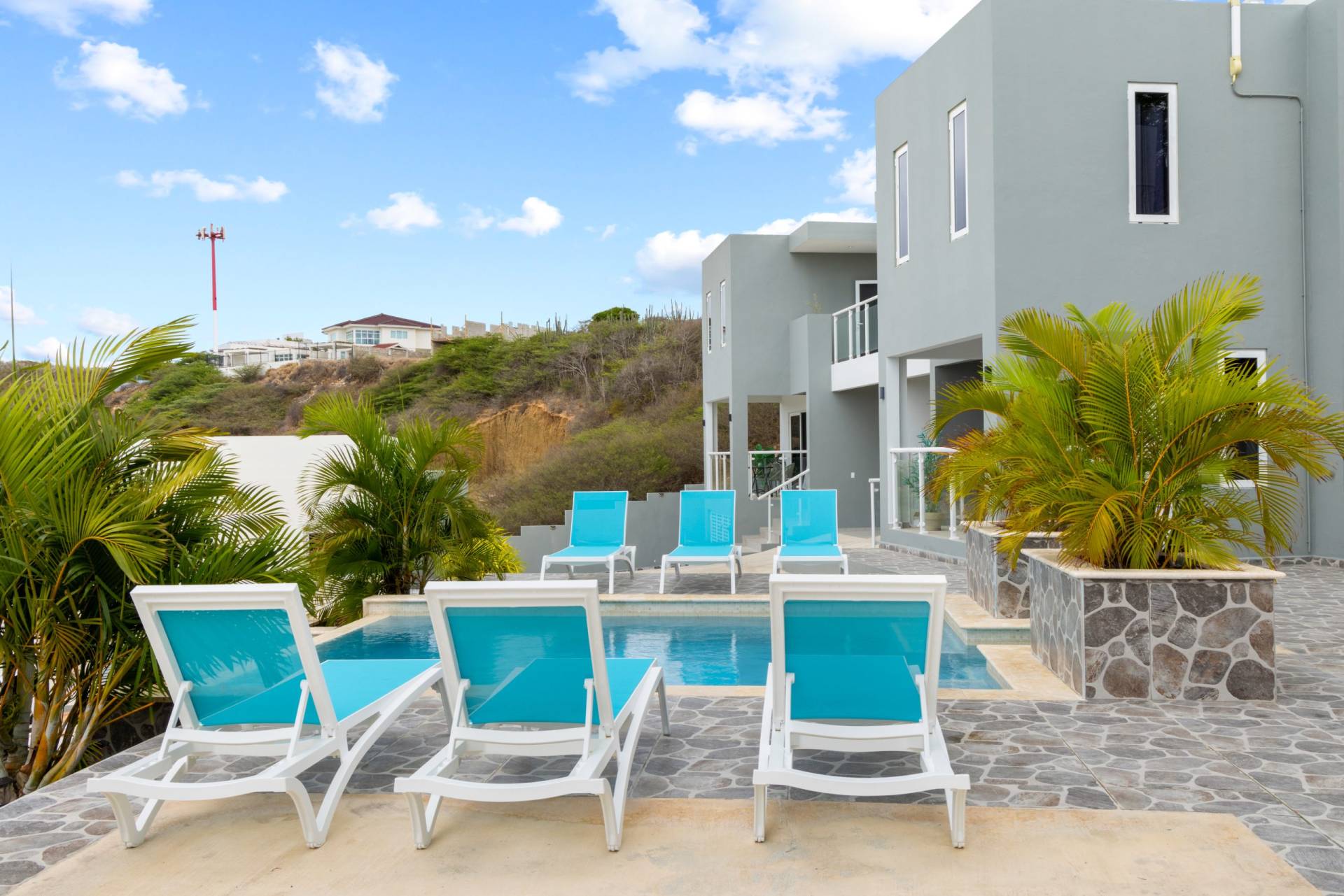 Curacao Casa. Neem een verfrissende duik in het gezamenlijke zwembad en ontspan op een van de ligbedjes.